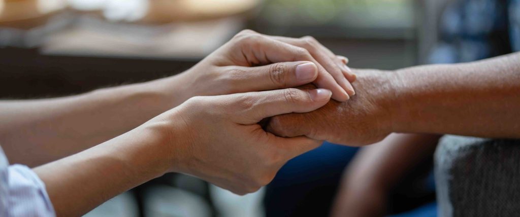 Hand of younger woman holding hand elderly woman, Helping hands, Take care for the elderly concept.