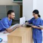 Nurses at doctor's office talking at front desk.