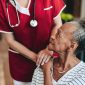Nurse or doctor comforting an elderly patient.